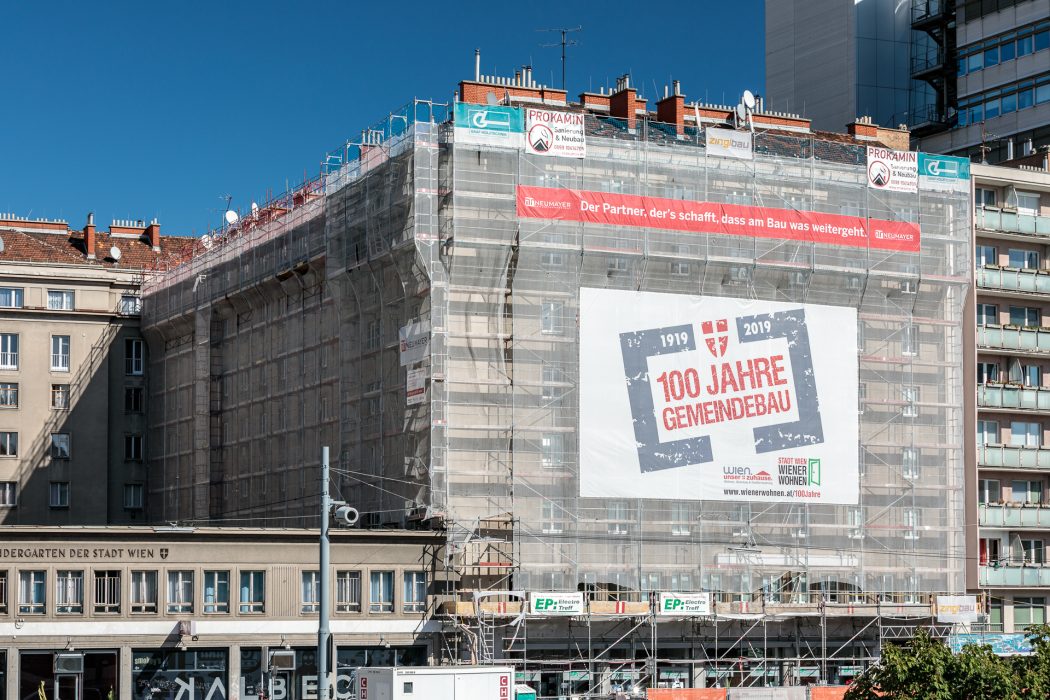 Ein Gebäude in Wien ist eingerüstet, mit einem Banner zum 100-jährigen Jubiläum des Gemeindebaus von 1919 bis 2019.