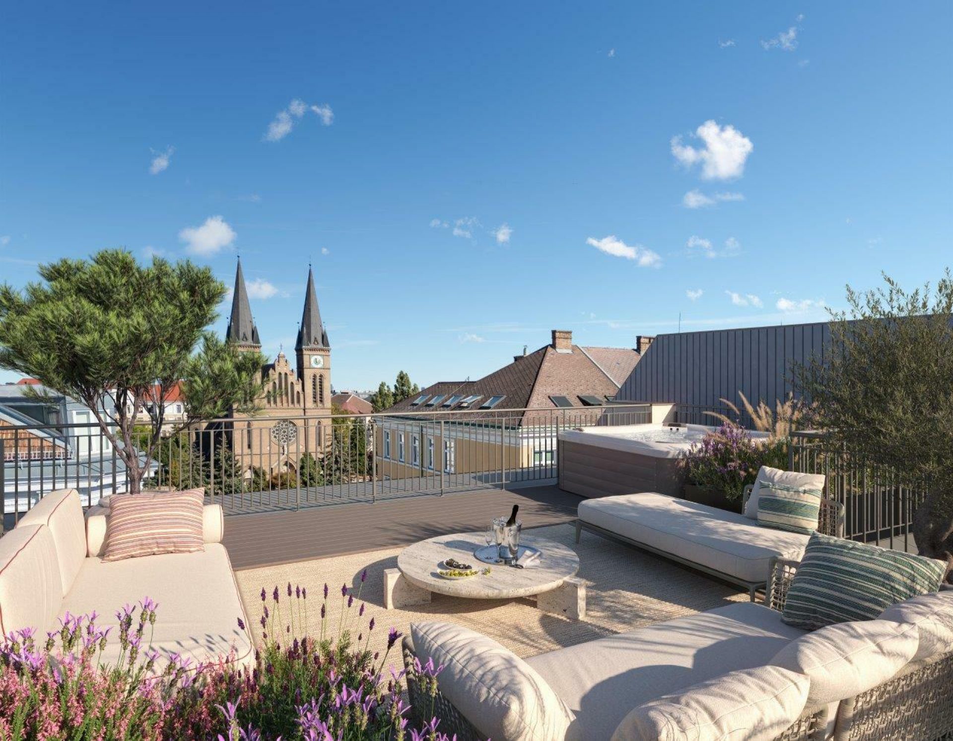 Eine elegante Dachterrasse mit Sofas, einem Tisch, Pflanzen und einer Aussicht auf eine Kirche mit zwei Türmen unter blauem Himmel.